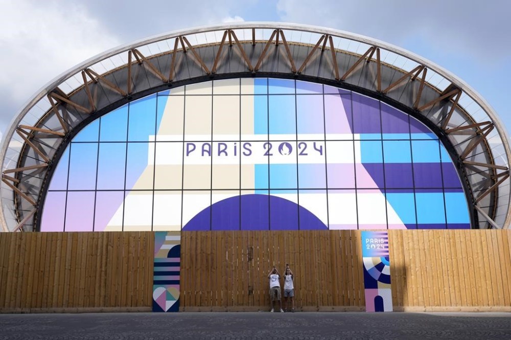 Tourists photograph near the Champ-de-Mars Arena, ahead of the 2024 Summer Olympics, Wednesday, July 24, 2024, in Paris, France. (AP Photo/Eugene Hoshiko)