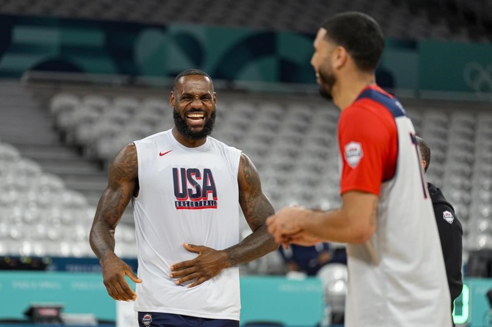 LeBron James, jokes with Jayson Tatum, as the United State's men's team practiced before the start of the basketball competition at the 2024 Summer Olympics, Wednesday, July 24, 2024 in Villeneuve-d'Ascq, France. (AP Photo/Michael Conroy)