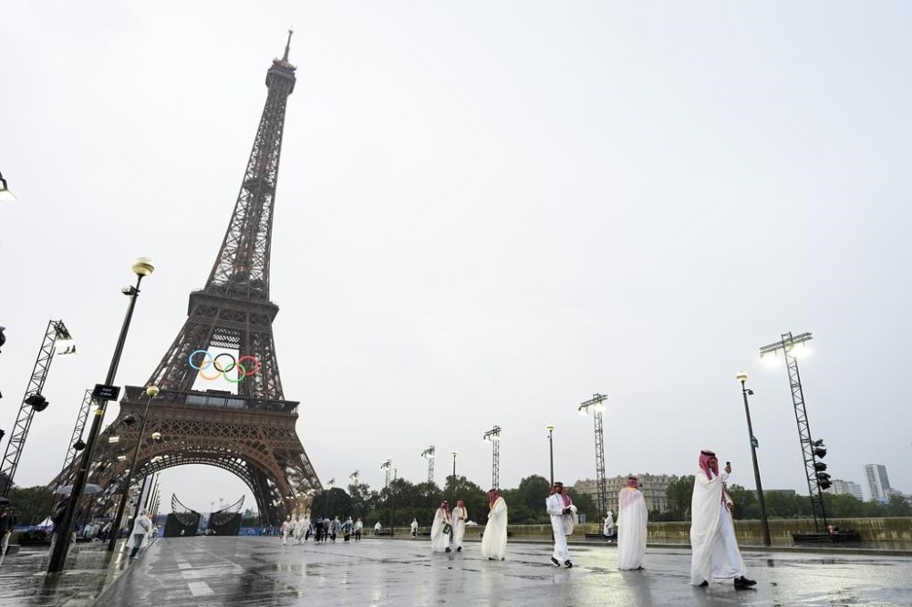 Saudi Arabia athletes walk across a bridge near the Eiffel Tower in Paris, France, during the opening ceremony of the 2024 Summer Olympics, Friday, July 26, 2024. (AP Photo/Andy Wong)