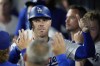 Los Angeles Dodgers' Freddie Freeman is high-fived in the dugout after scoring on a single by Teoscar Hernández during the sixth inning of a baseball game against the San Francisco Giants, Monday, July 22, 2024, in Los Angeles. (AP Photo/Marcio Jose Sanchez)