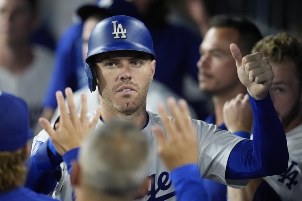 Los Angeles Dodgers' Freddie Freeman is high-fived in the dugout after scoring on a single by Teoscar Hernández during the sixth inning of a baseball game against the San Francisco Giants, Monday, July 22, 2024, in Los Angeles. (AP Photo/Marcio Jose Sanchez)