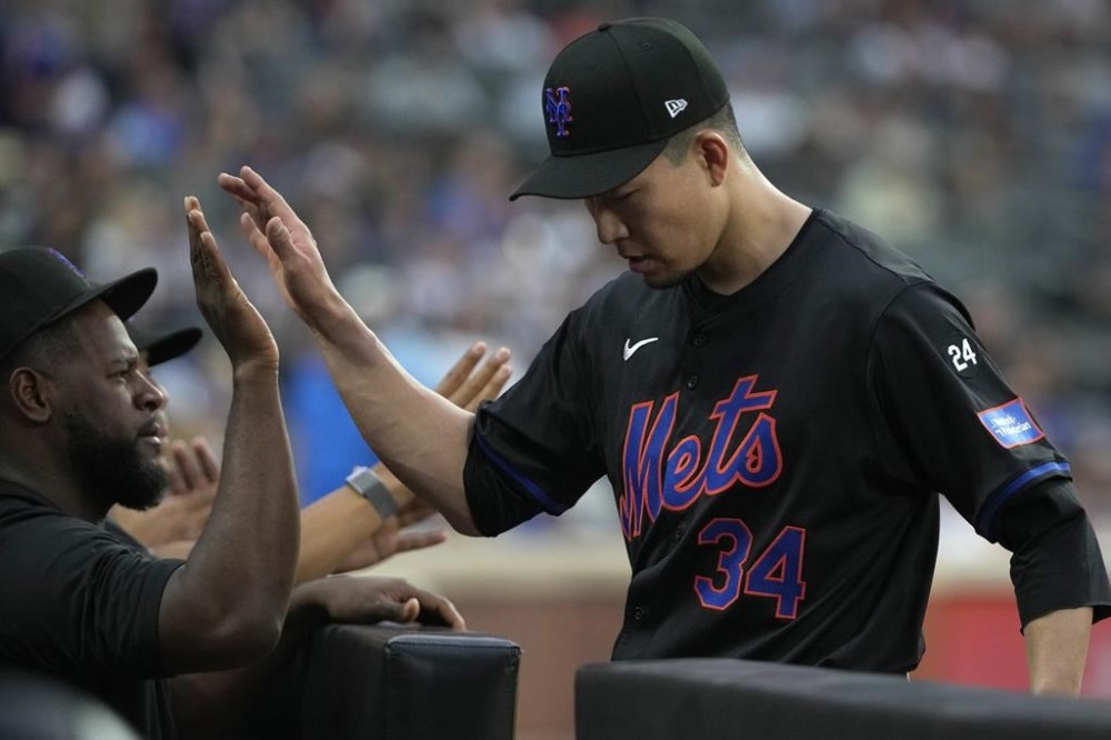 New York Mets' Kodai Senga, right, high-fives Luis Severino while walking into the dugout during the fourth inning of a baseball game against the Atlanta Braves, Friday, July 26, 2024, in New York. (AP Photo/Pamela Smith)
