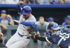 Chicago Cubs' Mike Tauchman, let, is tagged out at home plate by Kansas City Royals catcher Salvador Perez (13) after attempting to score from third off a flyout to right field by Miguel Amaya during the fifth inning of a baseball game in Kansas City, Mo., Friday, July 26, 2024. (AP Photo/Colin E. Braley)