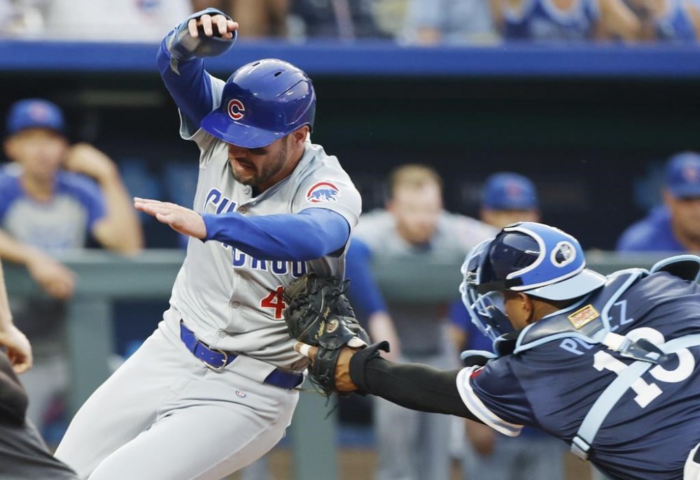 Chicago Cubs' Mike Tauchman, let, is tagged out at home plate by Kansas City Royals catcher Salvador Perez (13) after attempting to score from third off a flyout to right field by Miguel Amaya during the fifth inning of a baseball game in Kansas City, Mo., Friday, July 26, 2024. (AP Photo/Colin E. Braley)