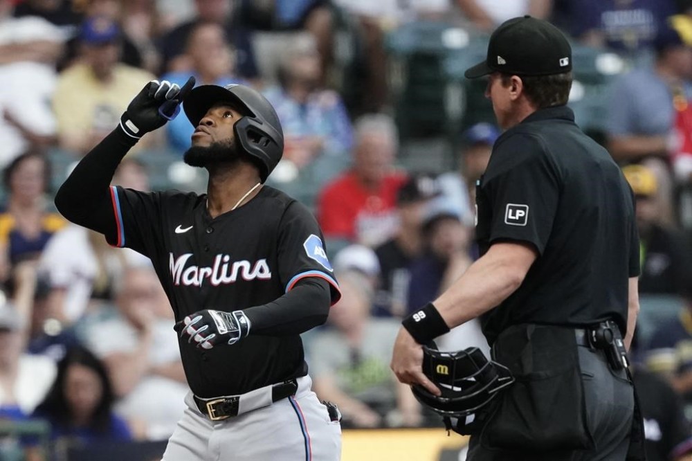 Miami Marlins' Bryan De La Cruz, left, gestures after hitting a two-run home run during the first inning of a baseball game against the Milwaukee Brewers, Friday, July 26, 2024, in Milwaukee. (AP Photo/Aaron Gash)
