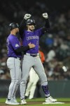 Colorado Rockies' Brenton Doyle, right, celebrates next to third base coach Warren Schaeffer after hitting a two-run triple against the San Francisco Giants during the eighth inning of a baseball game Friday, July 26, 2024, in San Francisco. (AP Photo/Godofredo A. Vásquez)