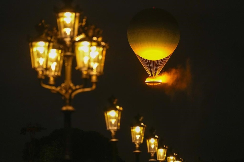 The Olympic Flame rises on a balloon after being lit in Paris, France, during the opening ceremony of the 2024 Summer Olympics, Friday, July 26, 2024. (AP Photo/Francisco Seco)