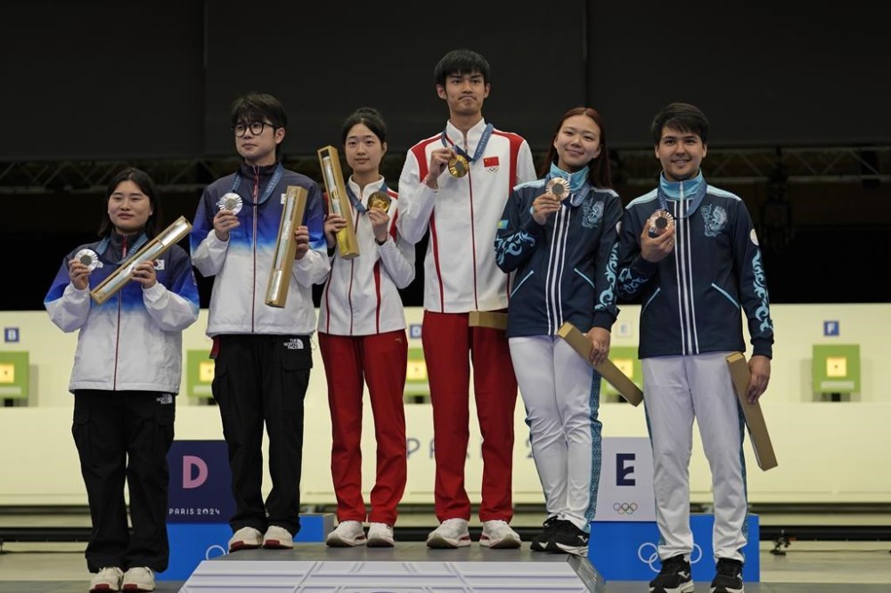 Medal winners pose for a photograph after the medal ceremony of the 10m air rifle mixed team competition at the 2024 Summer Olympics, Saturday, July 27, 2024, in Chateauroux, France. China's Sheng Lihao and Huang Yuting won the gold in the competion, while South Korea's Park Hajun and Keum Jihyeon took silver and Kazakhstan's Islam Satpayev and Alexandra Le took the bronze. (AP Photo/Manish Swarup)