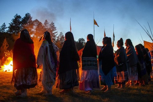 Mescalero Apache tribe women dance around a bonfire during a coming-of-age blessing ceremony for two young women in Mescalero, New Mexico, Saturday, July 13, 2024. (AP Photo/Andres Leighton)