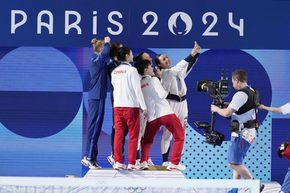 China's Chen Yiwen and Chang Yani, celebrate their gold medal, flanked by silver medal United States' Sarah Bacon and Kassidy Cook and Britain's Yasmin Harper and Scarlett Mew Jensen on the podium of the women's synchronised 3m springboard diving final at the 2024 Summer Olympics, Saturday, July 27, 2024, in Saint-Denis, France. (AP Photo/Lee Jin-man)