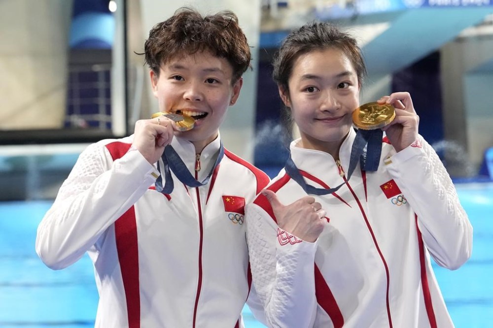 China's Chen Yiwen and Chang Yani hold their gold medal on the podium of the women's synchronised 3m springboard diving final at the 2024 Summer Olympics, Saturday, July 27, 2024, in Saint-Denis, France. (AP Photo/Lee Jin-man)