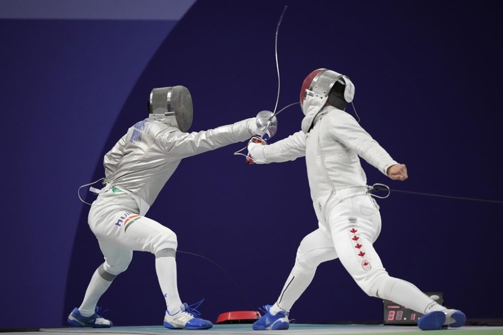 Hungary's Aron Szilagyi, left, and Canada's Fares Arfa compete in the men's individual Sabre round of 32 competition during the 2024 Summer Olympics at the Grand Palais, Saturday, July 27, 2024, in Paris, France. (AP Photo/Andrew Medichini)