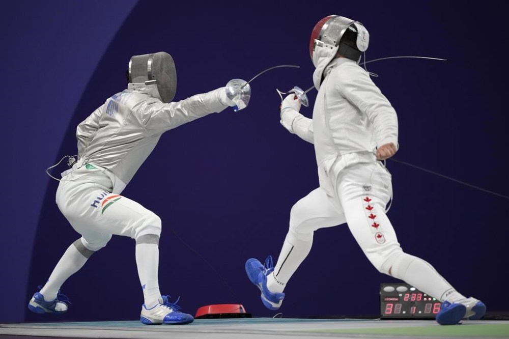 Hungary's Aron Szilagyi, left, and Canada's Fares Arfa compete in the men's individual Sabre round of 32 competition during the 2024 Summer Olympics at the Grand Palais, Saturday, July 27, 2024, in Paris, France. THE CANADIAN PRESS/AP/Andrew Medichini