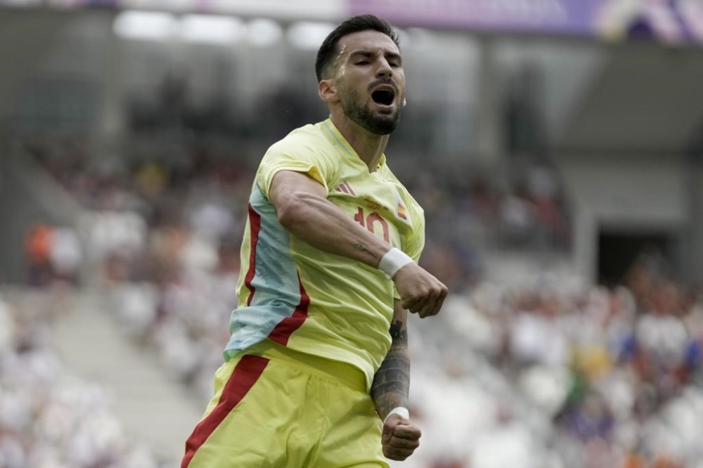 Spain's Alex Baena celebrates after scoring his side's 2nd goal against Dominican Republic during the men's Group C soccer match at the Bordeaux stadium at the 2024 Summer Olympics, Saturday, July 27, 2024, in Bordeaux, France. (AP Photo/Moises Castillo)
