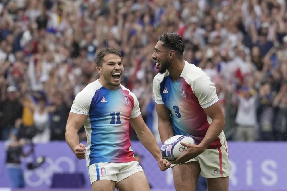Rayan Rebbadj of France, right, celebrates after scoring a try with teammate Antoine Dupont of France during the men's semifinal Rugby Sevens match between South Africa and France at the 2024 Summer Olympics, in the Stade de France, in Saint-Denis, France, Saturday, July 27, 2024. (AP Photo/Vadim Ghirda)