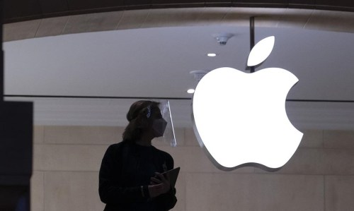 FILE - An Apple store employee stands inside the store in New York on Feb. 5, 2021. The International Association of Machinists and Aerospace Workers’ Coalition of Organized Retail Employees, which represents the employees at a Apple store location in Maryland, announced Friday, July 26, 2024 that it struck a three-year deal with the company that will increase pay by an average of 10% and offer other benefits to workers. (AP Photo/Mark Lennihan, File )