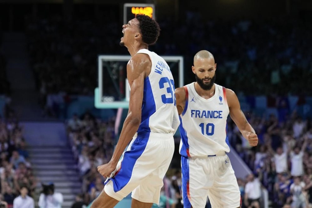 Victor Wembanyama, of France, celebrates with Evan Fournier, after making a basket and being fouled by Brazil in a men's basketball game at the 2024 Summer Olympics, Saturday, July 27, 2024 in Villeneuve-d'Ascq, France. (AP Photo/Mark J. Terrill)