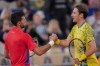 Serbian tennis player Novak Djokovic shakes hands with Matthew Ebden of Australia at the end of the men's singles tennis competition, at the 2024 Summer Olympics, Saturday, July 27, 2024, in Paris, France. (AP Photo/Manu Fernandez)
