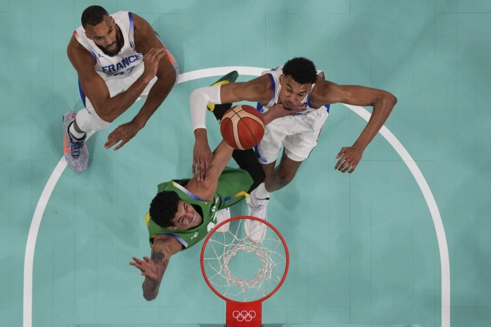 Gui Santos, of Brazil, shoots in front of Victor Wembanyama, of France, in a men's basketball game at the 2024 Summer Olympics, Saturday, July 27, 2024, in Villeneuve-d'Ascq, France. (Brian Snyder/Pool Photo via AP)