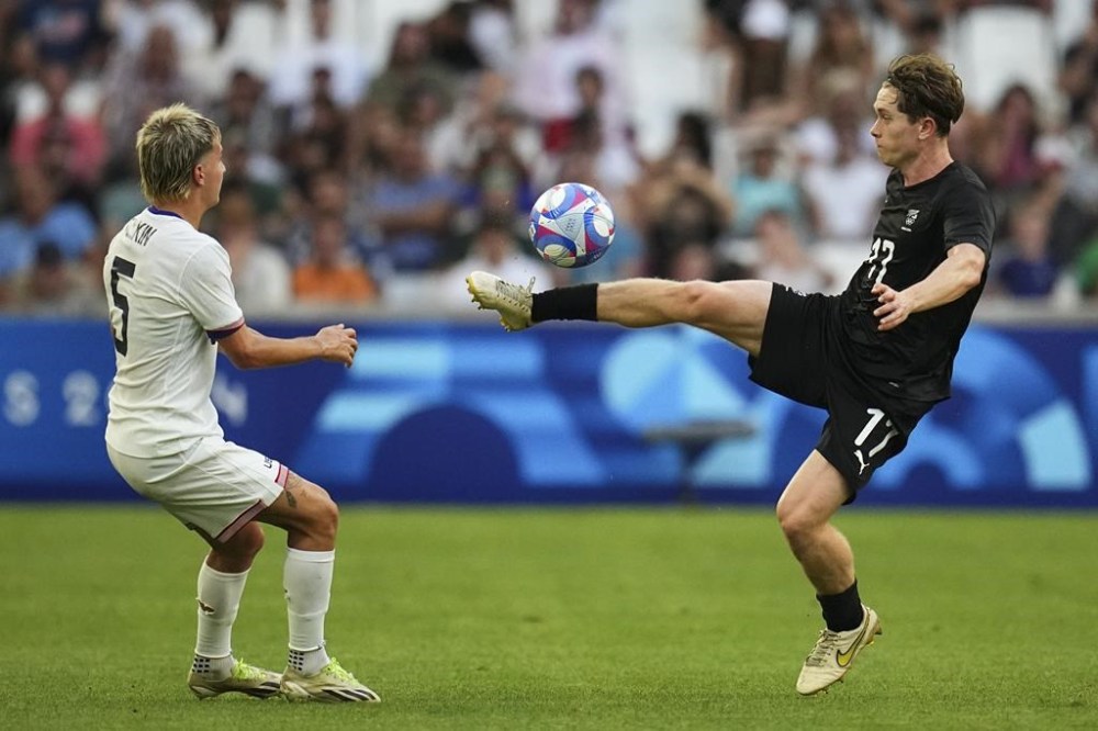 New Zealand's Lachlan Bayliss, right, and United States' John Tolkin battle for the ball during the men's Group A soccer match between New Zealand and the United States at the Velodrome stadium, during the 2024 Summer Olympics, Saturday, July 27, 2024, in Marseille, France. (AP Photo/Daniel Cole)