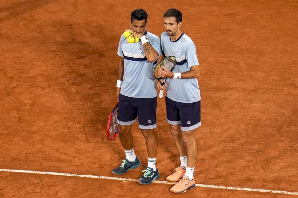 Andres Molteni and Maximo Gonzalez from the Argentina team talk during the men's doubles tennis competition against Carlos Alcaraz, left, and Rafael Nadal from the Spanish team, at the 2024 Summer Olympics, Saturday, July 27, 2024, in Paris, France. (AP Photo/Manu Fernandez)