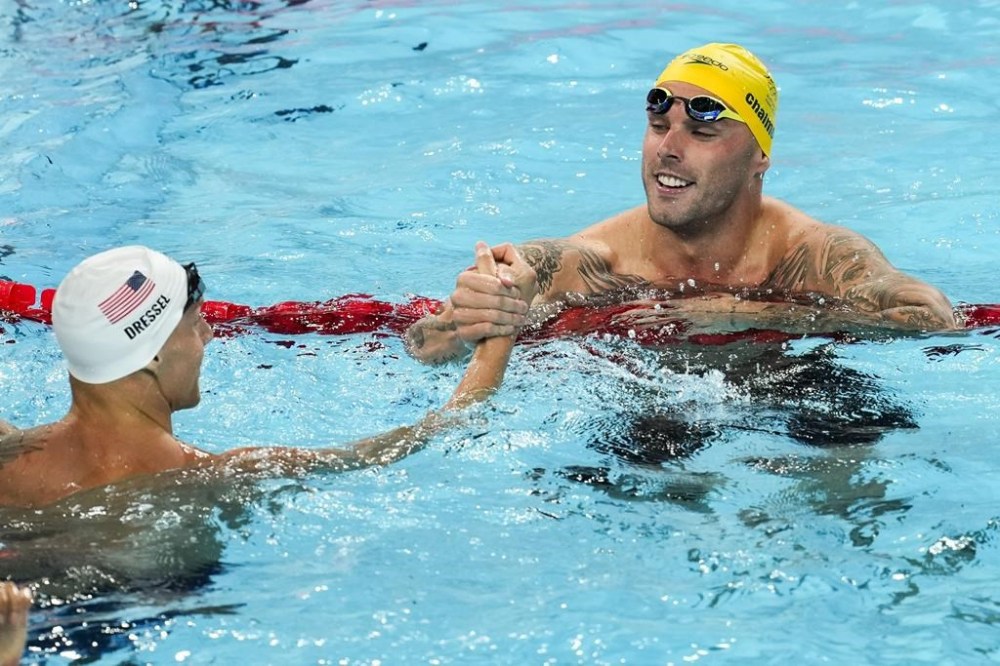 Caeleb Dressel, of the United States, left, and Kyle Chalmers, of Australia, shake hands after a heat in the men's 4x100-meter freestyle relay at the 2024 Summer Olympics, Saturday, July 27, 2024, in Nanterre, France. (AP Photo/Martin Meissner)