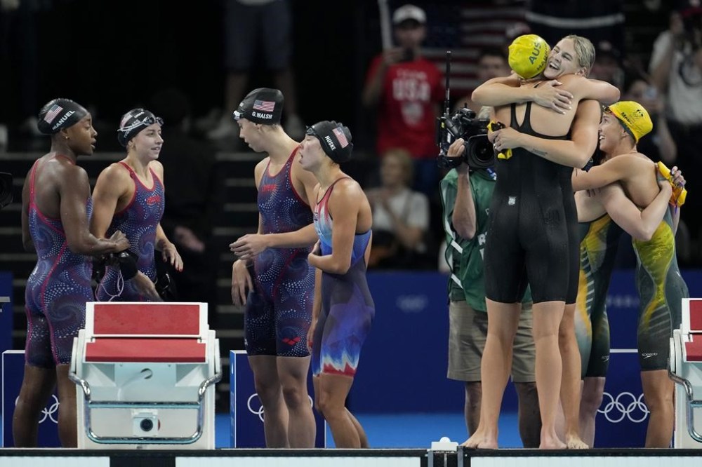 Swimmers from Australia, right, celebrate after winning the women's 4x100-meter freestyle relay final as the United States team, left, reacts at the 2024 Summer Olympics, Saturday, July 27, 2024, in Nanterre, France. (AP Photo/Matthias Schrader)