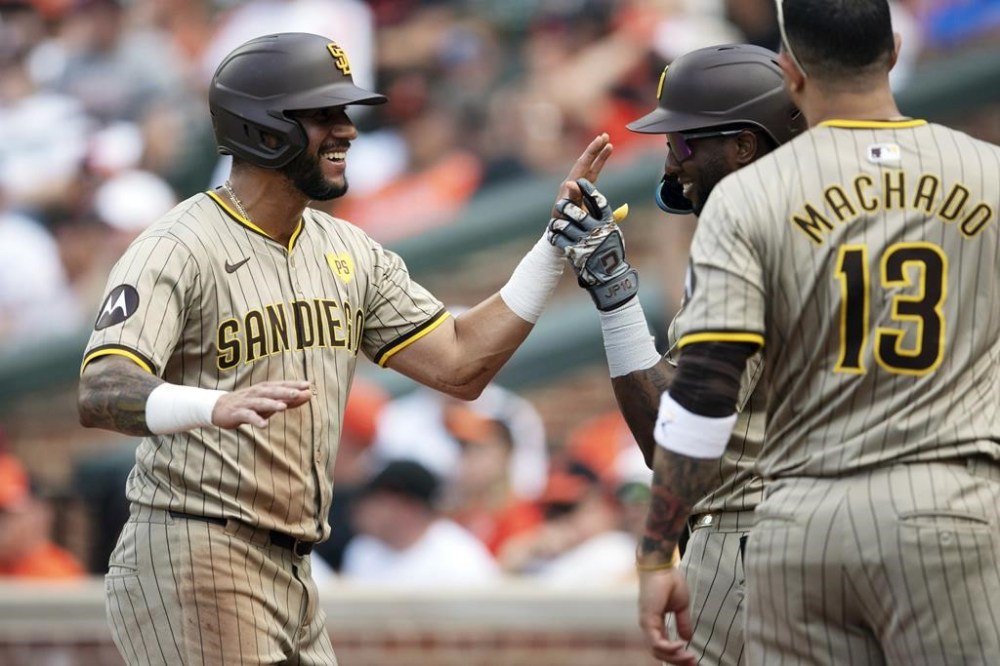 San Diego Padres first base Luis Arraez, left, celebrates with his teammates after scoring in the second inning of a baseball game against Baltimore Orioles, Saturday, July 27, 2024, in Baltimore. (AP Photo/Jose Luis Magana)