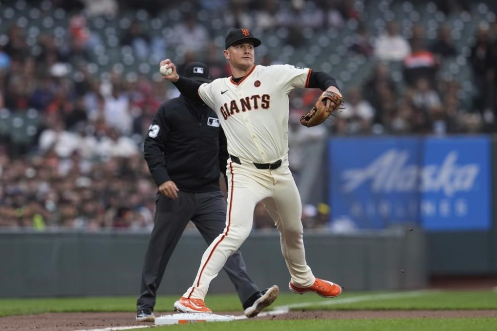 San Francisco Giants third baseman Matt Chapman turns a double play after forcing out Colorado Rockies' Kris Bryant at third to end the first game of a baseball doubleheader, Saturday, July 27, 2024, in San Francisco. Michael Toglia was out at first. (AP Photo/Godofredo A. Vásquez)