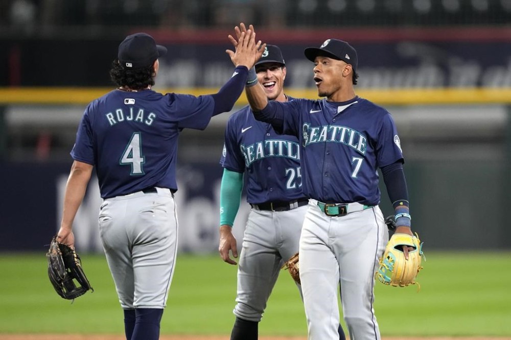 Seattle Mariners' Josh Rojas, left, Jorge Polanco (7) and Dylan Moore celebrate the team's 6-3 win over the Chicago White Sox after a baseball game Saturday, July 27, 2024, in Chicago. (AP Photo/Charles Rex Arbogast)