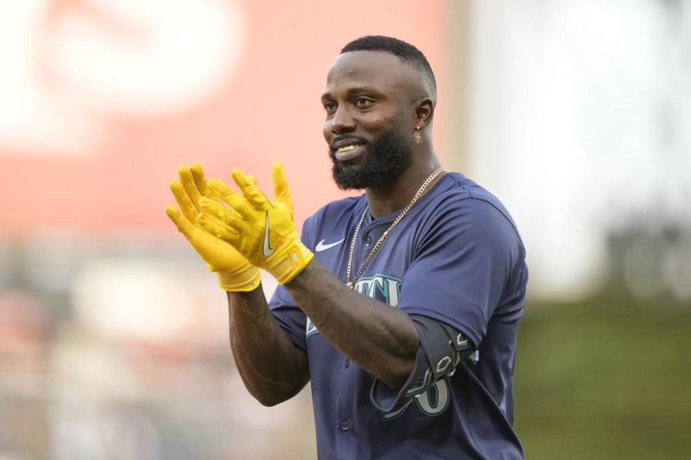 Seattle Mariners' Randy Arozarena looks back to the dugout and applauds after recording his first hit as a Mariner, a single during the third inning of a baseball game against the Chicago White Sox on Saturday, July 27, 2024, in Chicago. (AP Photo/Charles Rex Arbogast)