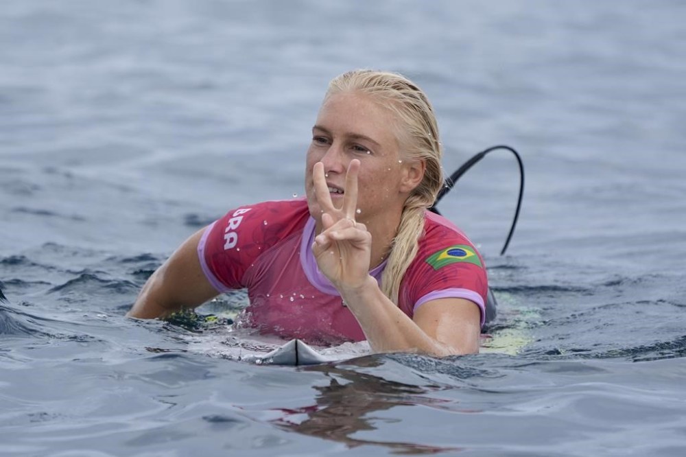 Tatiana Weston-Webb, of Brazil, reacts after getting second in her heat during the first round of the 2024 Summer Olympics surfing competition Saturday, July 27, 2024, in Teahupo'o, Tahiti. (AP Photo/Gregory Bull)