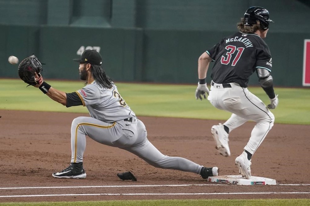Arizona Diamondbacks' Jake McCarthy (31) beats the throw to Pittsburgh Pirates' Connor Joe (2) for a hit during the first inning of a baseball game, Saturday, July 27, 2024, in Phoenix. (AP Photo/Darryl Webb)