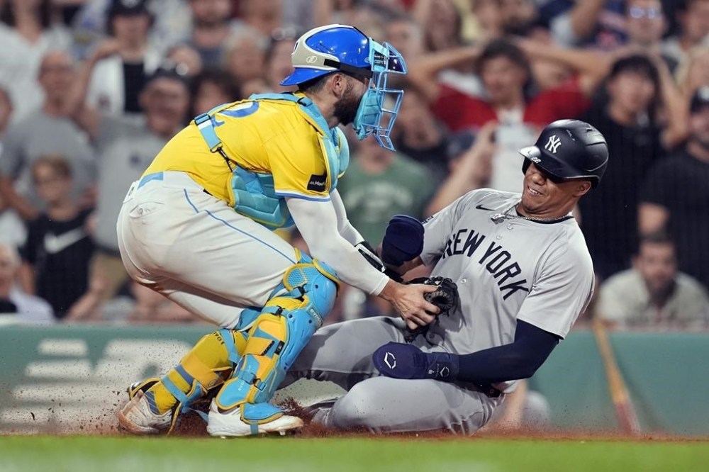 Boston Red Sox catcher Connor Wong, left, tags New York Yankees' Juan Soto trying to score on a double by Aaron Judge during the eighth inning of a baseball game, Saturday, July 27, 2024, in Boston. (AP Photo/Michael Dwyer)
