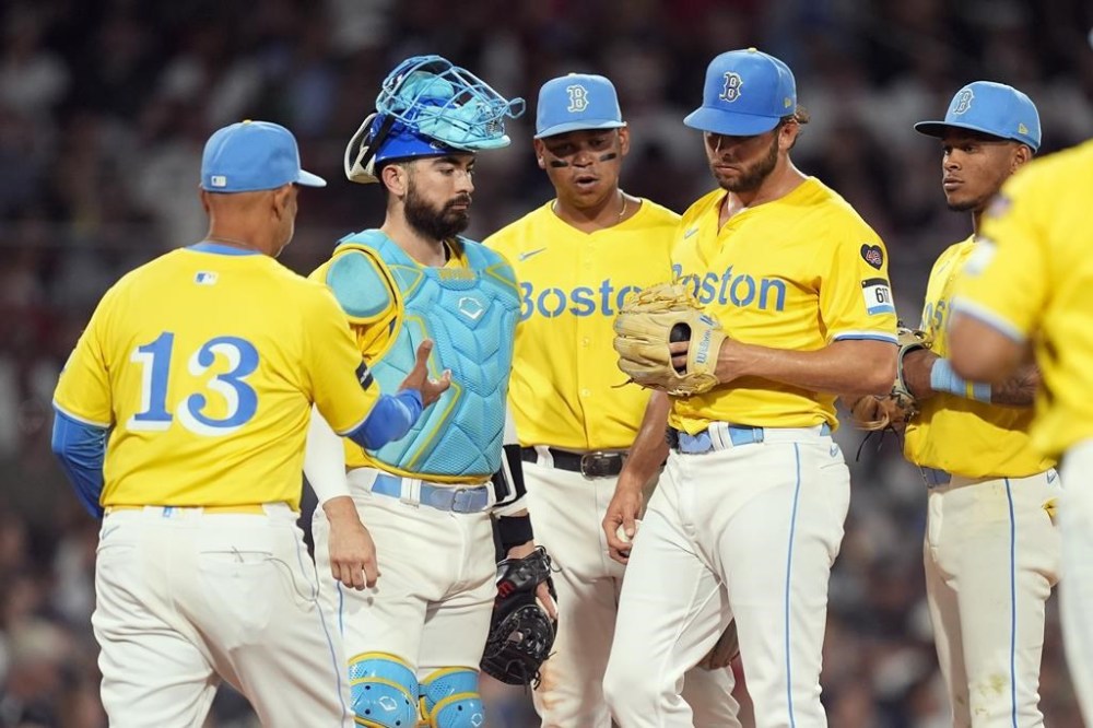 Boston Red Sox manager Alex Cora (13) comes to the mound to relieve starting pitcher Kutter Crawford, second from right, during the fifth inning of a baseball game against the New York Yankees, Saturday, July 27, 2024, in Boston. (AP Photo/Michael Dwyer)