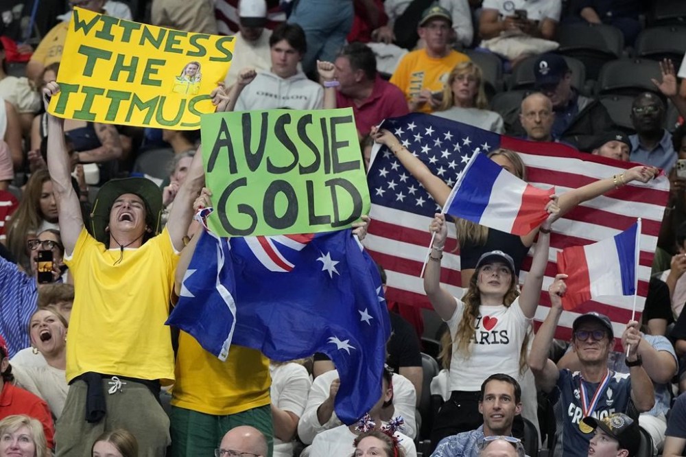 Supporters react as they watch the 4x100-meter relay finals at the 2024 Summer Olympics, Saturday, July 27, 2024, in Nanterre, France. (AP Photo/Matthias Schrader)