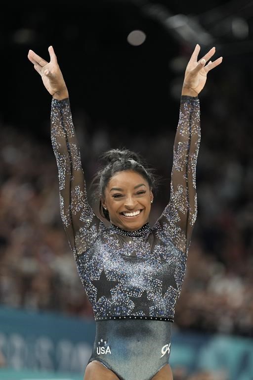 Simone Biles smiles after competing on the balance beam during a women's artistic gymnastics qualification round at the 2024 Summer Olympics, Sunday, July 28, 2024, in Paris, France. (AP Photo/Abbie Parr)