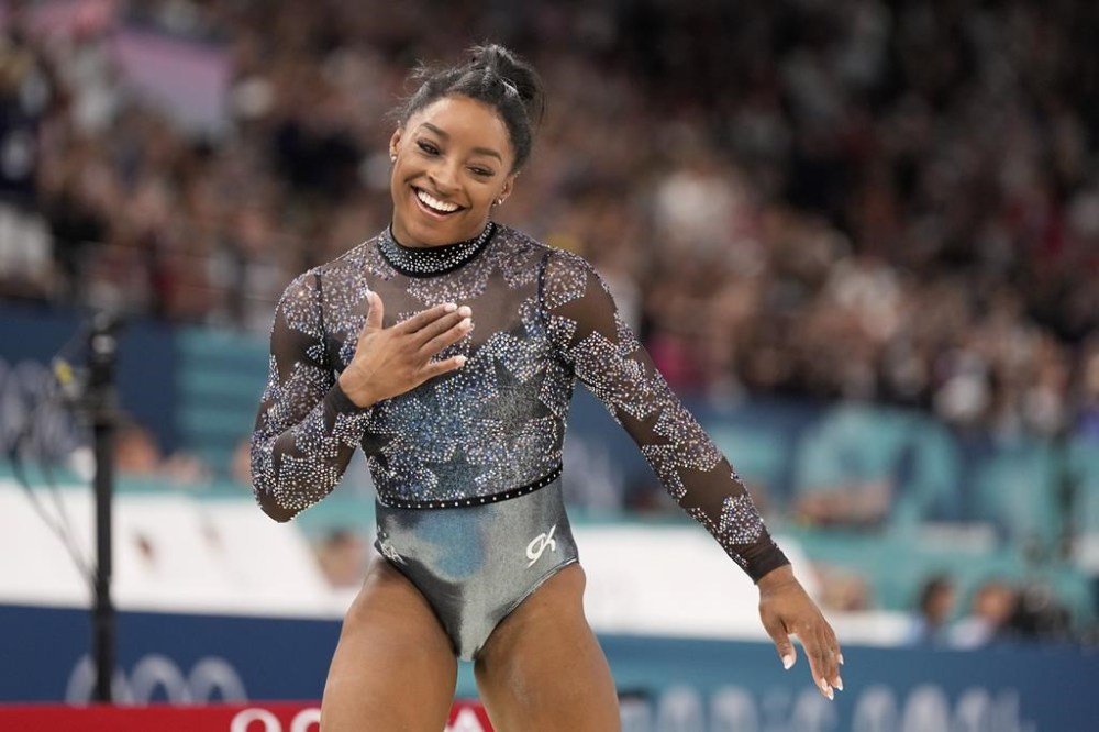 Simone Biles competes on the balance beam during a women's artistic gymnastics qualification round at the 2024 Summer Olympics at Bercy Arena, Sunday, July 28, 2024, in Paris, France. (AP Photo/Abbie Parr)