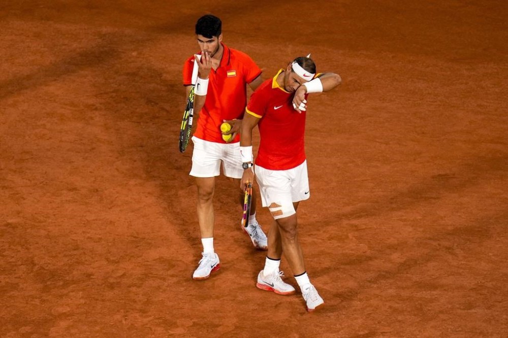 Carlos Alcaraz, left, and Rafael Nadal from the Spanish team react during the men's doubles tennis competition against Andres Molteni and Maximo Gonzalez from the Argentina team, at the 2024 Summer Olympics, Saturday, July 27, 2024, in Paris, France. (AP Photo/Manu Fernandez)