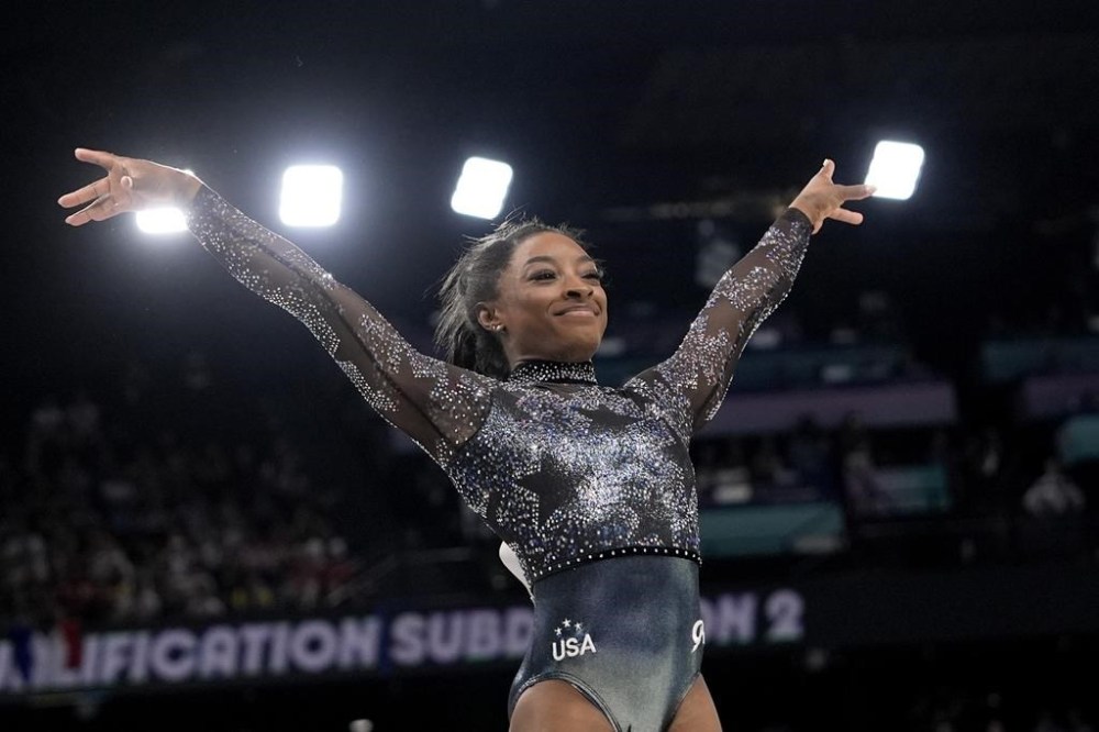 Simone Biles, of United States, smiles after competing on the vault during a women's artistic gymnastics qualification round at Bercy Arena at the 2024 Summer Olympics, Sunday, July 28, 2024, in Paris, France. (AP Photo/Charlie Riedel)