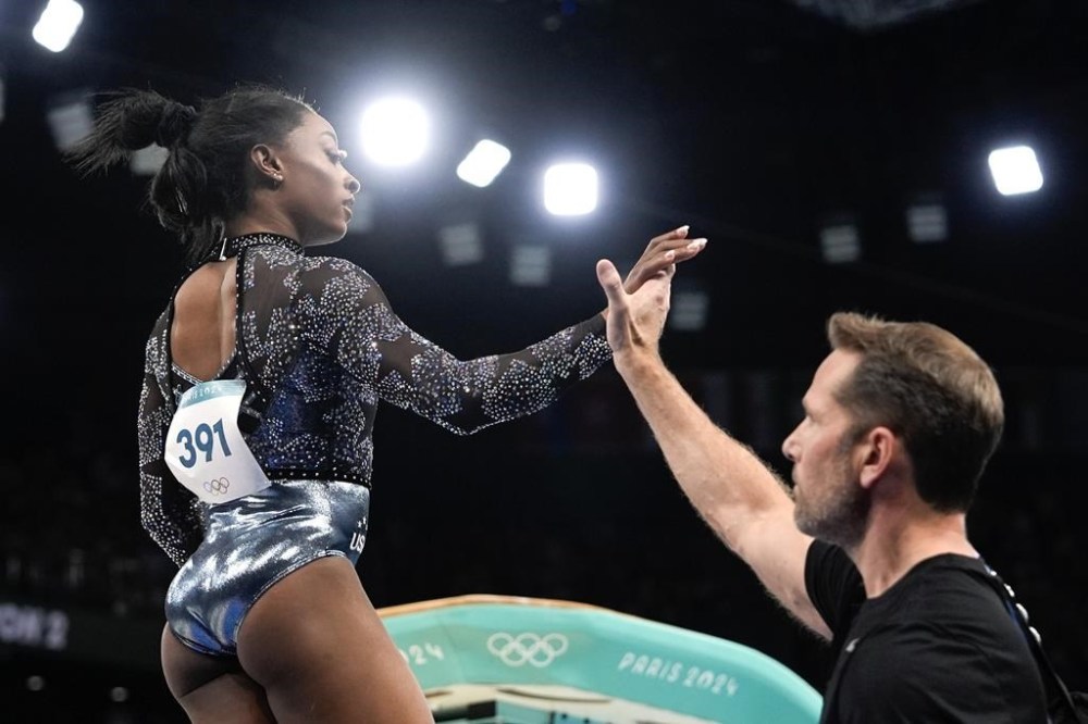 Simone Biles, of United States, prepares to compete on the vault during a women's artistic gymnastics qualification round at Bercy Arena at Bercy Arena at the 2024 Summer Olympics, Sunday, July 28, 2024, in Paris, France. (AP Photo/Charlie Riedel)