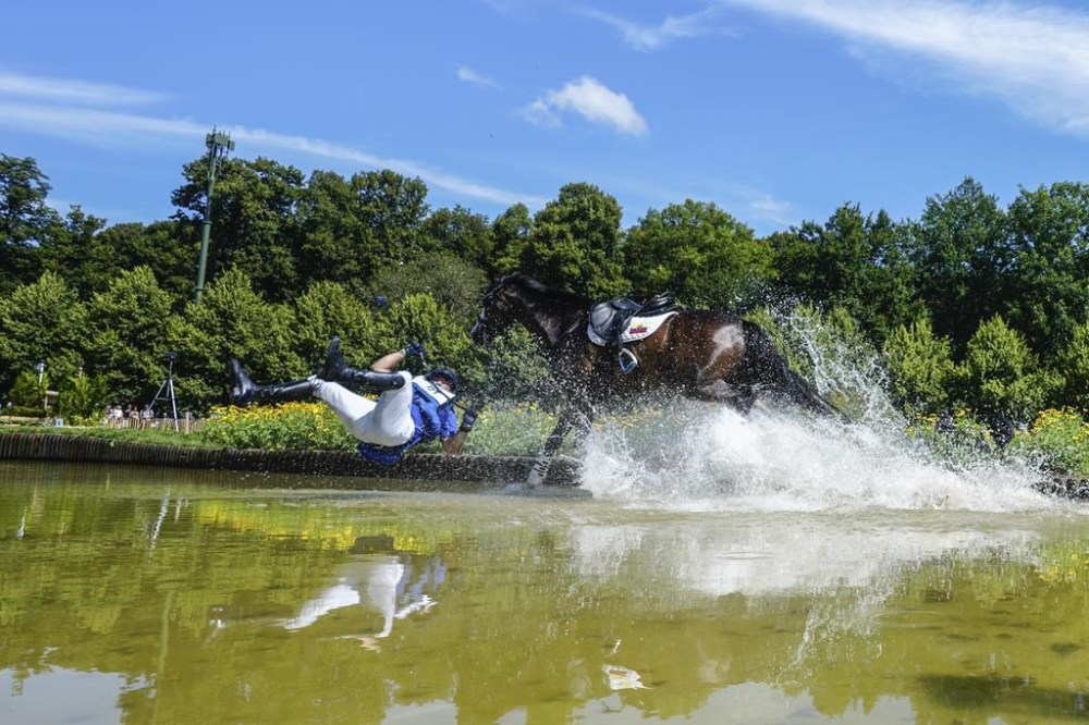 Ecuador's Ronald Zabala G., riding, Forever Young Wundermaske, fall off their horse during the Equestrian Cross Country competition at Chateau de Versailles for the 2024 Summer Olympics, Sunday, July 28, 2024, in Versailles, France. (AP Photo/Mosa'ab Elshamy)
