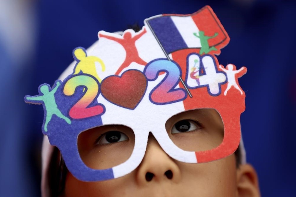 A spectator watches the opening ceremony for the 2024 Summer Olympics in Paris, France, Friday, July 26, 2024. (Steph Chambers/Pool Photo via AP)