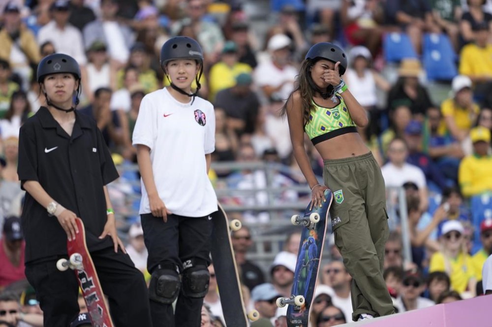 Rayssa Leal, of Brazil, right, gestures during the women's skateboard street final at the 2024 Summer Olympics, Sunday, July 28, 2024, in Paris, France. At left is Liz Akama, of Japan, and center Coco Yoshizawa, also of Japan.(AP Photo/Vadim Ghirda)