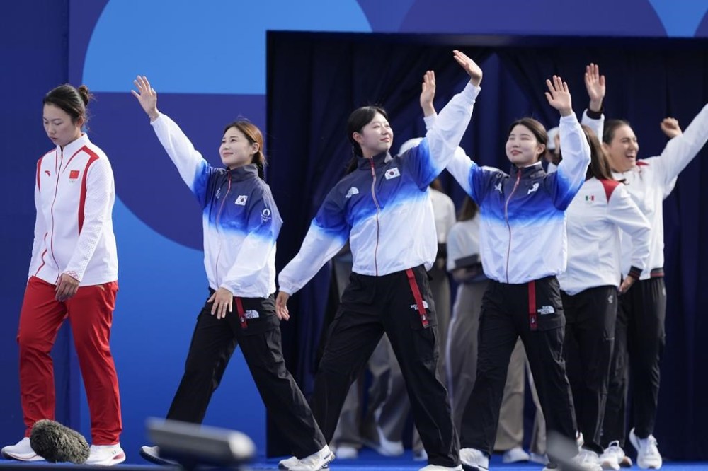 South Korea arrives for the medal ceremony during Archery at the 2024 Summer Olympics, Sunday, July 28, 2024, in Paris, France. (AP Photo/Rebecca Blackwell)