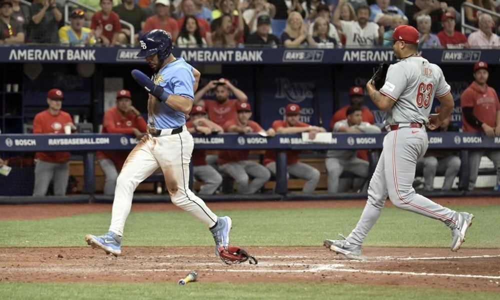 Cincinnati Reds reliever Fernando Cruz (63) races to cover home plate as Tampa Bay Rays' José Caballero, left, scores from third base on a pitch in the dirt during the eighth inning of a baseball game Sunday, July 28, 2024, in St. Petersburg, Fla. (AP Photo/Steve Nesius)
