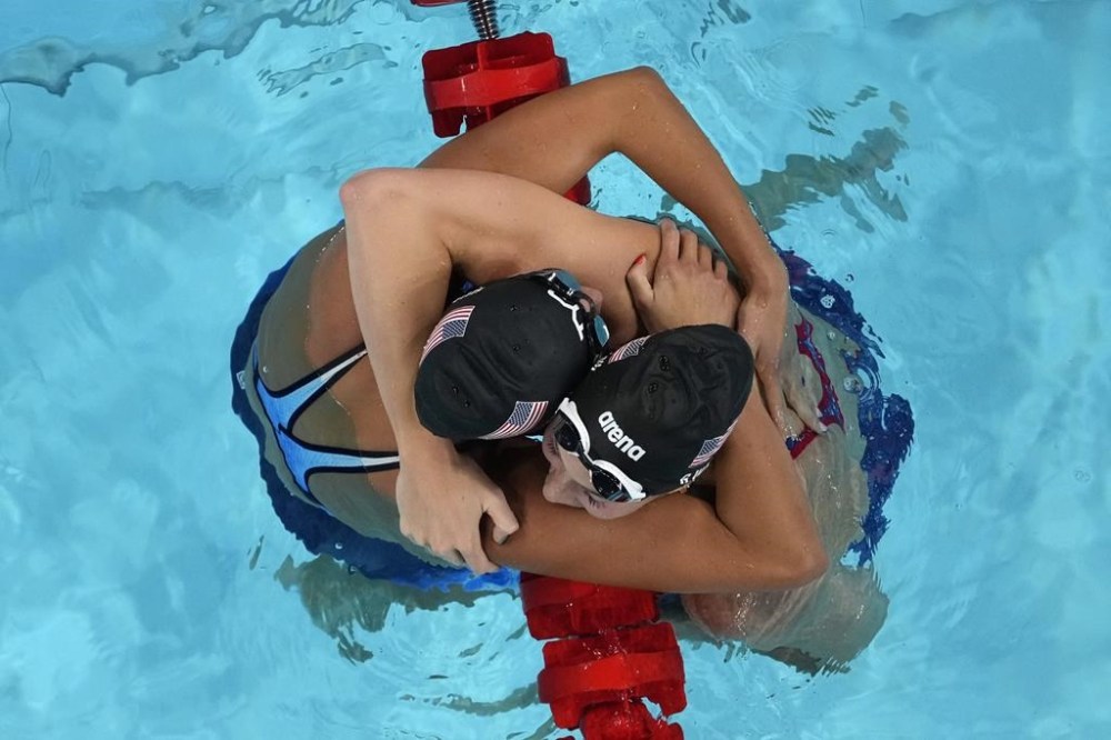 Torri Huske, left, and Gretchen Walsh, of the United States, hug after the women's 100-meter butterfly final at the 2024 Summer Olympics, Sunday, July 28, 2024, in Nanterre, France. Huske won gold and Walsh won silver. (AP Photo/David J. Phillip)
