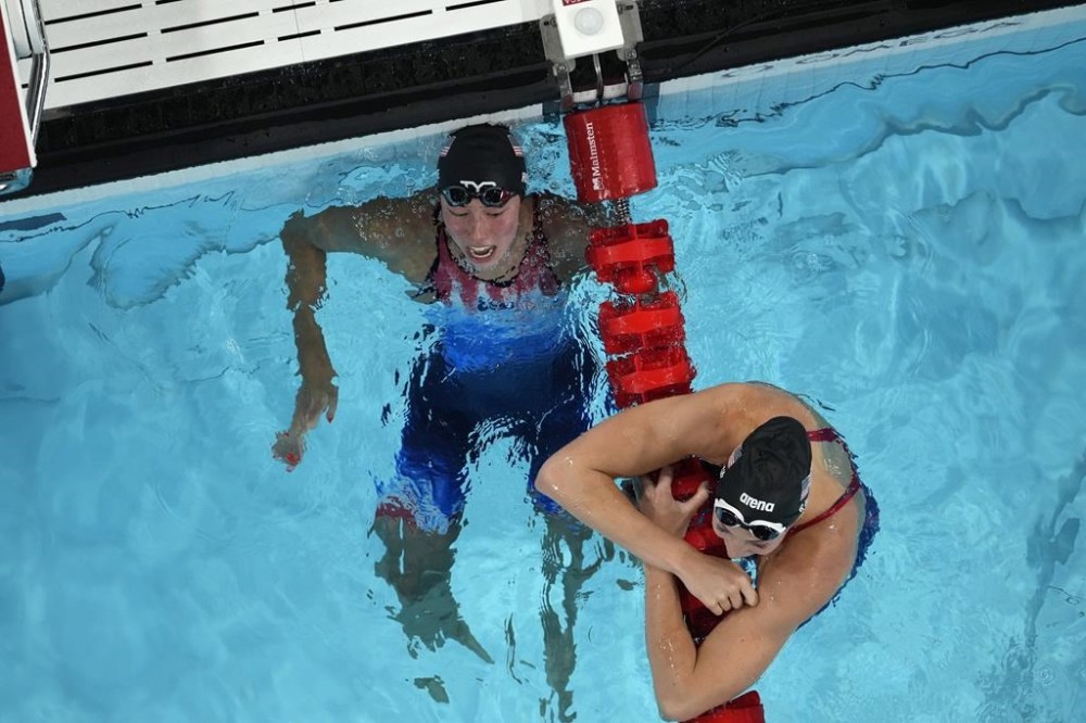 Torri Huske, left, and Gretchen Walsh, of the United States, react after the women's 100-meter butterfly final at the 2024 Summer Olympics, Sunday, July 28, 2024, in Nanterre, France. Huske won gold and Walsh won silver. (AP Photo/David J. Phillip)