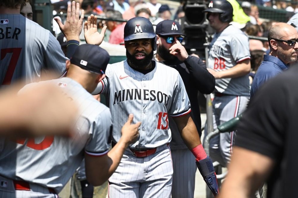 Minnesota Twins' Manuel Margot, center, is congratulated by teammates after scoring on a sacrifice fly by Brooks Lee against the Detroit Tigers during the second inning of a baseball game, Sunday, July 28, 2024, in Detroit. (AP Photo/Jose Juarez)