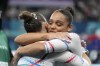 Ming van Eijken, of France, left, hugs teammate Melanie dos Santos de Jesus after the vault during a women's artistic gymnastics qualification round at Bercy Arena at the 2024 Summer Olympics, Sunday, July 28, 2024, in Paris, France. (AP Photo/Abbie Parr)